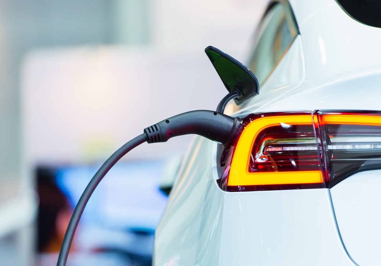 Close up of the Hybrid car electric charger station with power supply plugged into an electric car being charged.