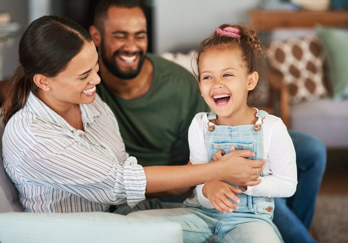 Her laughter rings with delight around the house. a mother tickling her little daughter while relaxing together at home
