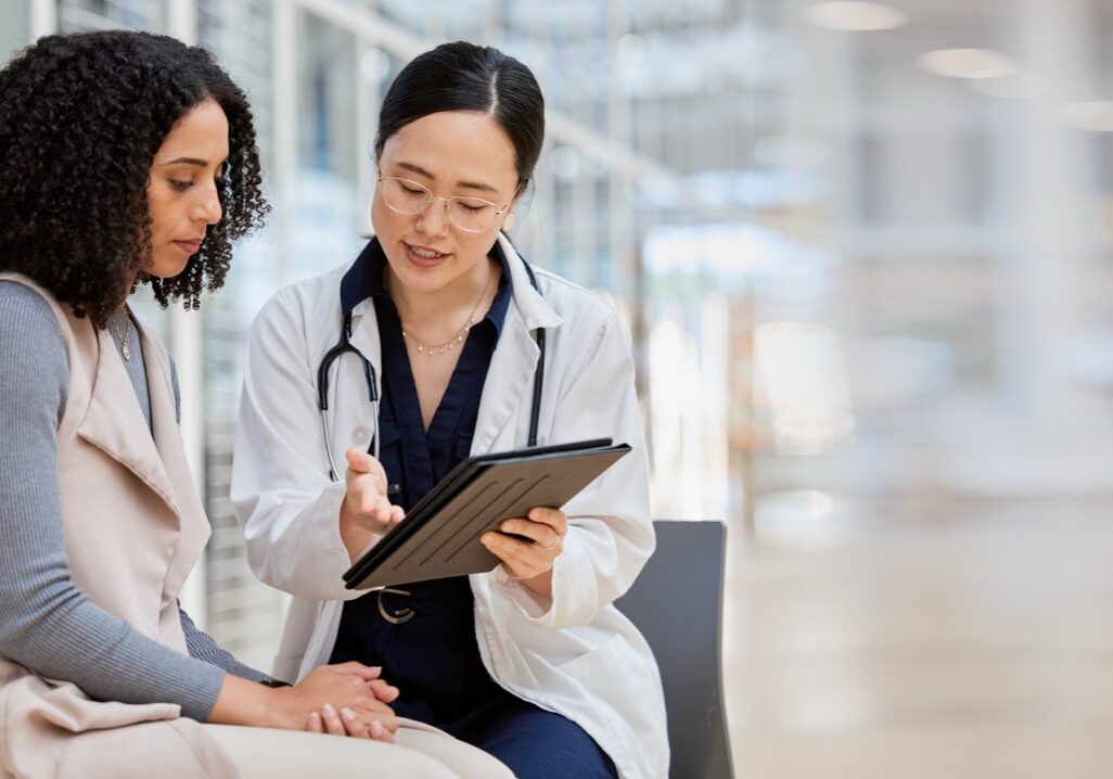 Doctor, woman patient and tablet for consulting with results, medical info and talk for healthcare with mockup space. Japanese medic, digital touchscreen or show video for surgery, wellness or advice.